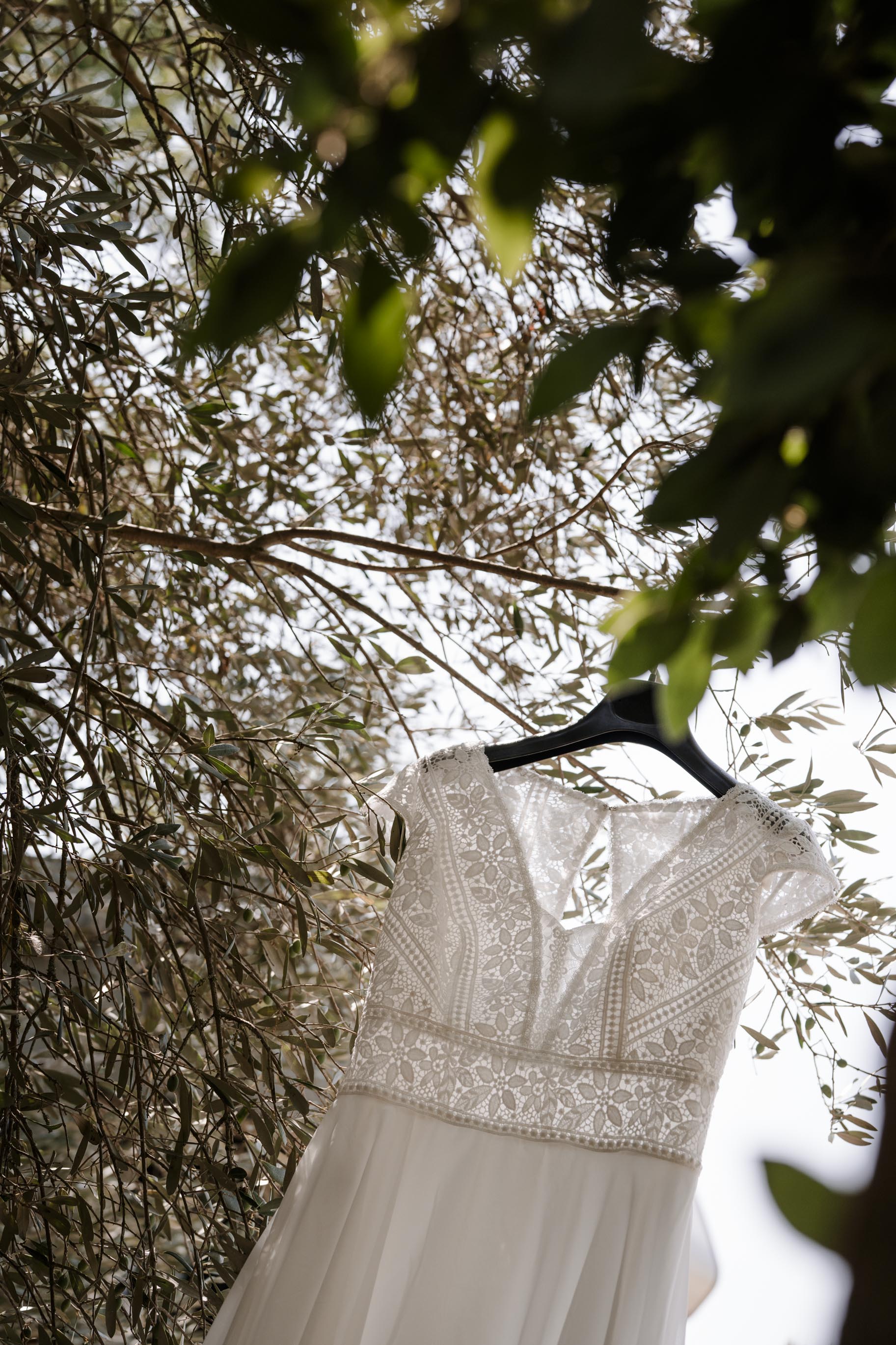 Robe de mariée suspendue dans un olivier, avant la cérémonie