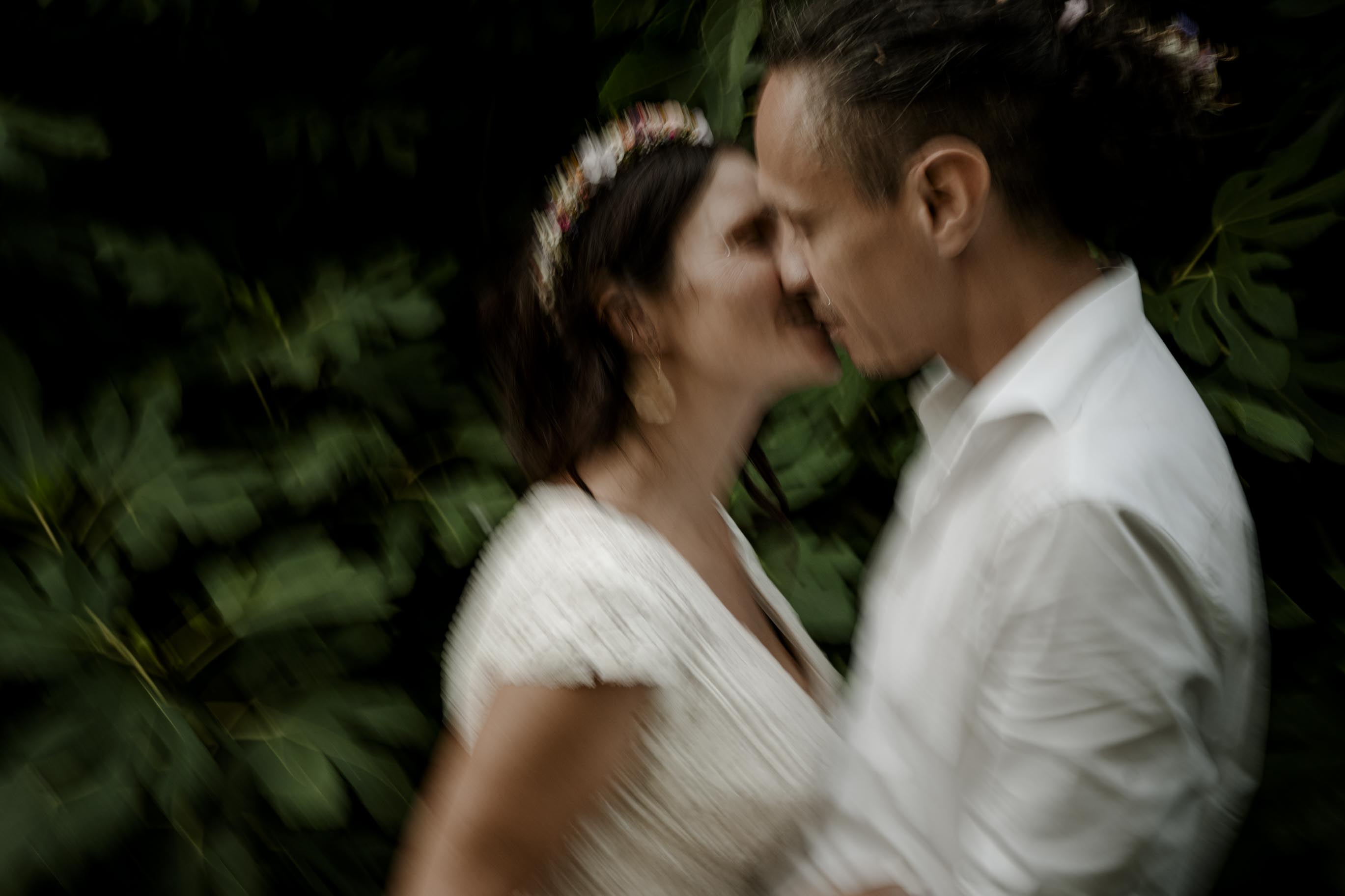 Mariés s'embrassant, moment tendre en lumière chaude